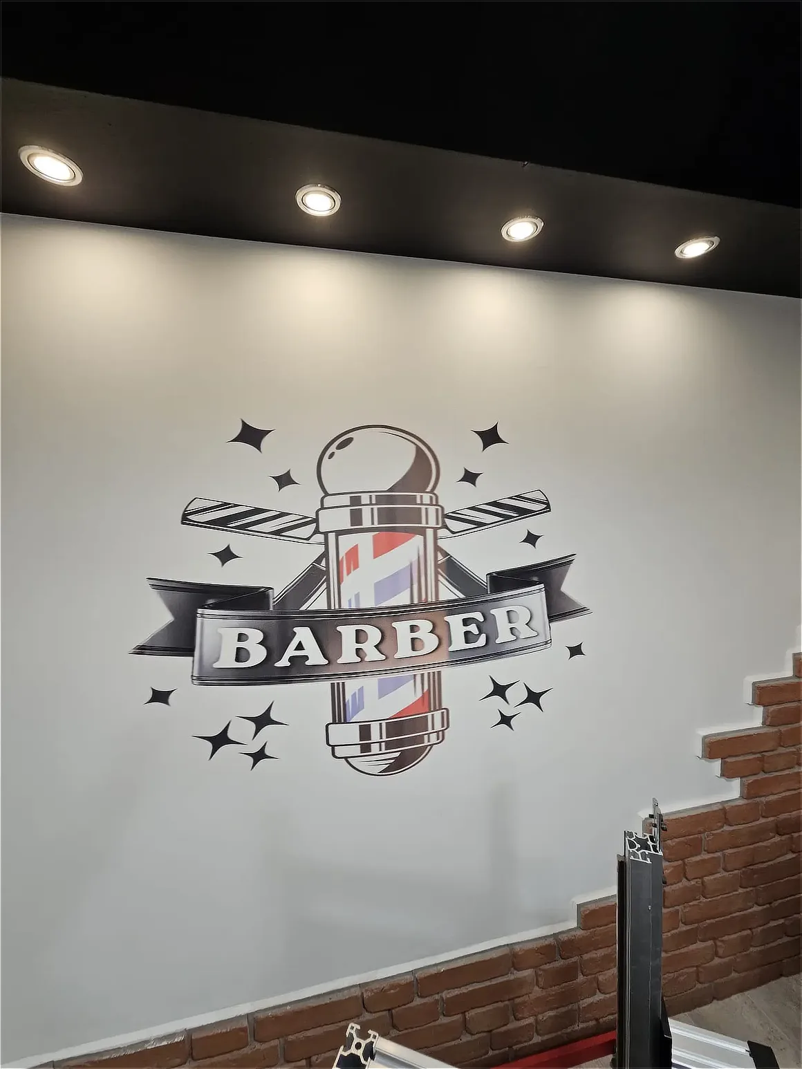 Logo Barber wydrukowane na ścianie zakładu fryzjerskiego - ujęcie drugie