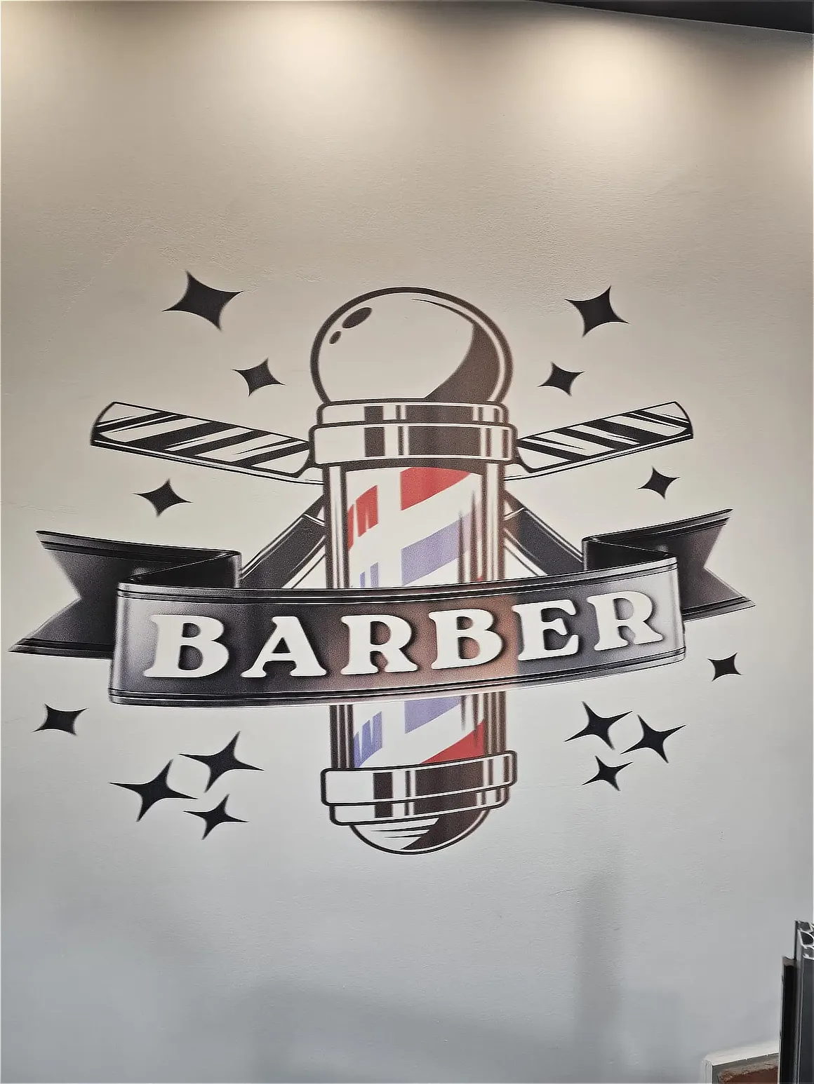 Logo Barber wydrukowane na ścianie zakładu fryzjerskiego